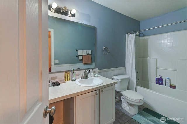 full bathroom with vanity, a wainscoted wall, shower / tub combo, tile patterned floors, and toilet