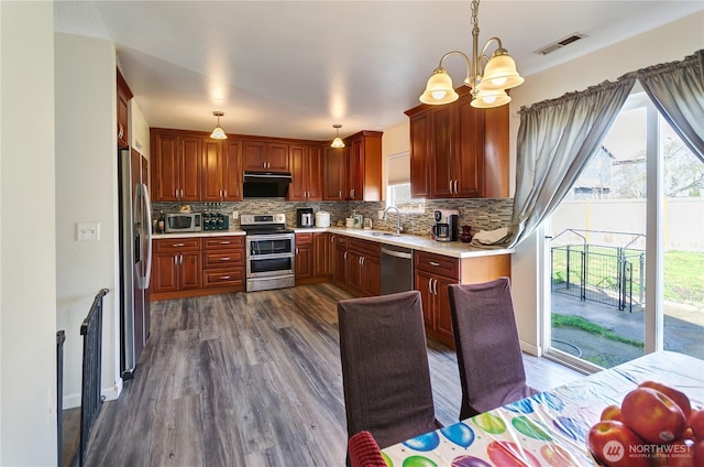 kitchen with visible vents, backsplash, appliances with stainless steel finishes, and light countertops