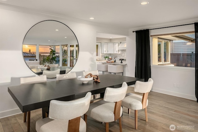 dining space with recessed lighting, baseboards, crown molding, and light wood-style floors