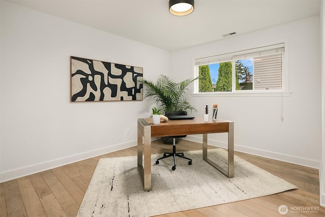 office with visible vents, baseboards, and wood finished floors