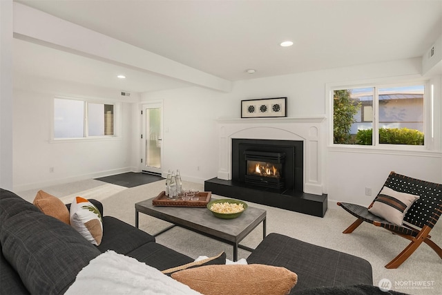 living area featuring a glass covered fireplace, recessed lighting, baseboards, and carpet floors