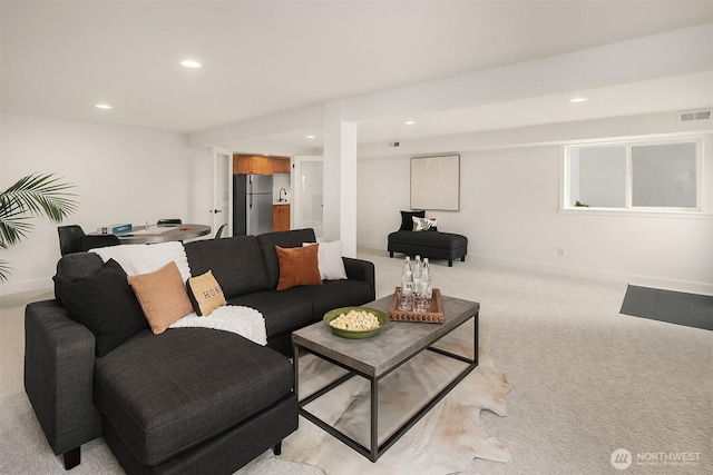 living room with recessed lighting, visible vents, light carpet, and baseboards