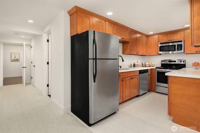 kitchen with light countertops, recessed lighting, brown cabinets, and stainless steel appliances