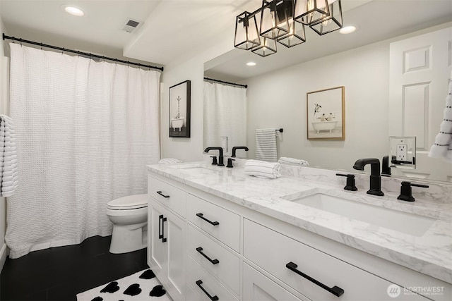 bathroom with double vanity, recessed lighting, toilet, and a sink