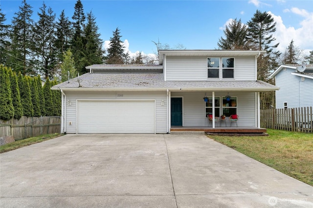 traditional home with fence, driveway, covered porch, a front lawn, and a garage