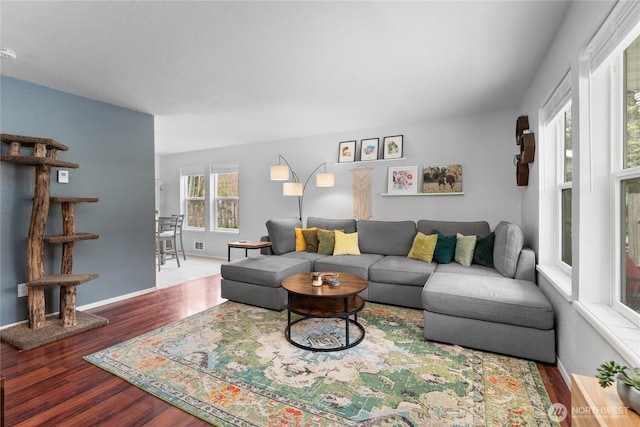 living room with visible vents, wood finished floors, and baseboards