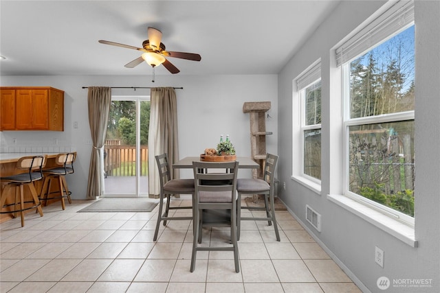 dining space with light tile patterned floors, visible vents, baseboards, and a ceiling fan