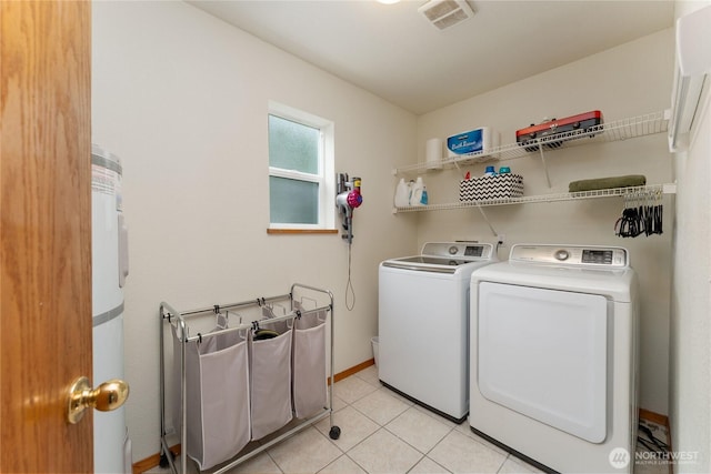 laundry area featuring visible vents, separate washer and dryer, light tile patterned floors, baseboards, and laundry area