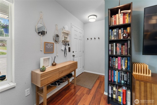 interior space featuring baseboards and wood finished floors