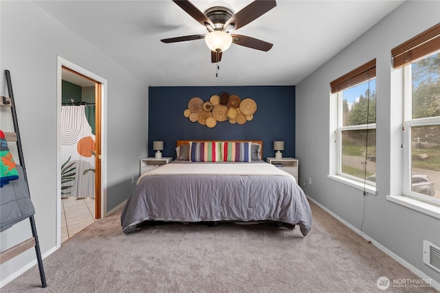 bedroom featuring baseboards, carpet, ceiling fan, and an accent wall