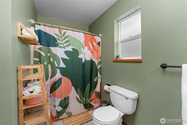 bathroom featuring curtained shower, toilet, and a textured wall