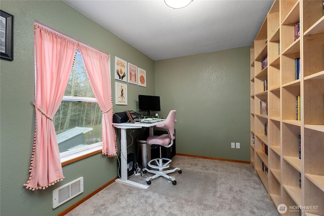 carpeted office featuring visible vents and baseboards