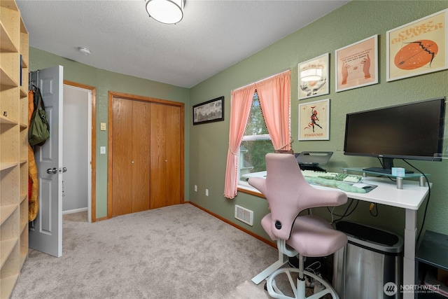 carpeted office space featuring visible vents, a textured ceiling, and baseboards