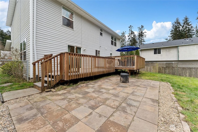 rear view of house with a yard, a patio area, fence, and a wooden deck