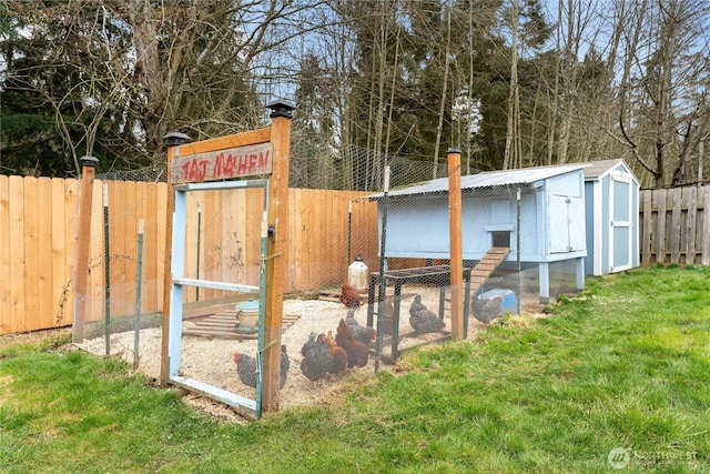 view of poultry coop featuring a lawn and fence