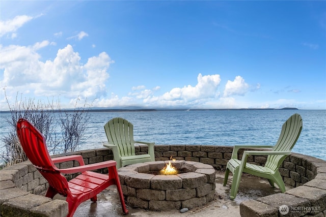 balcony with an outdoor fire pit and a water view