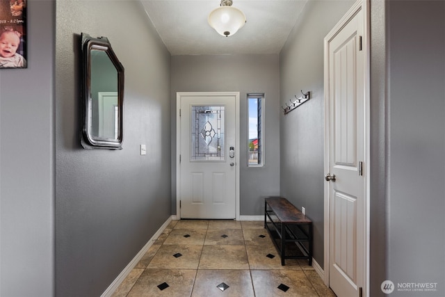 doorway featuring light tile patterned flooring and baseboards