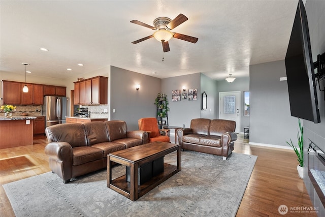 living room featuring recessed lighting, baseboards, wood finished floors, and a ceiling fan