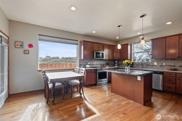 kitchen featuring backsplash, a center island, recessed lighting, stainless steel appliances, and light wood-style floors