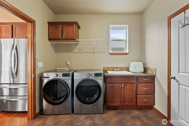 laundry area featuring washer and clothes dryer, cabinet space, baseboards, and a sink