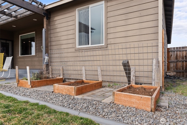 view of side of home with a garden and fence