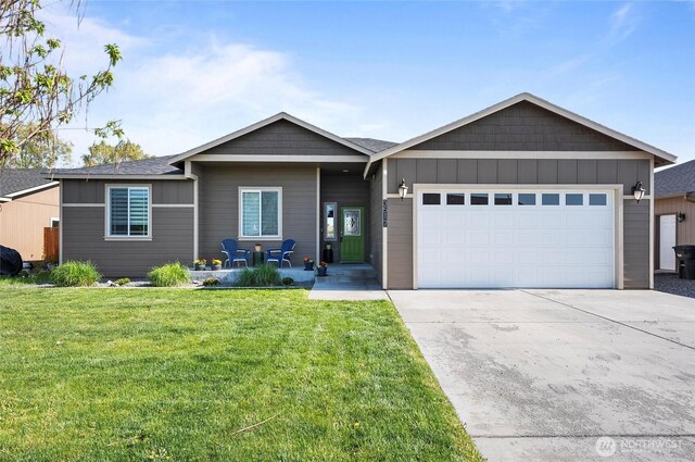 ranch-style house with board and batten siding, an attached garage, driveway, and a front lawn