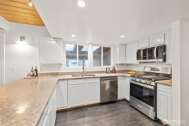 kitchen with recessed lighting, dark wood-style flooring, a sink, appliances with stainless steel finishes, and white cabinetry