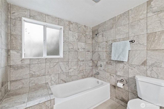 bathroom featuring tile patterned flooring,  shower combination, toilet, and tile walls