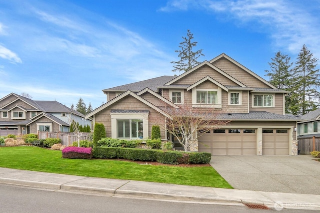 craftsman inspired home featuring a front yard, concrete driveway, fence, and a garage