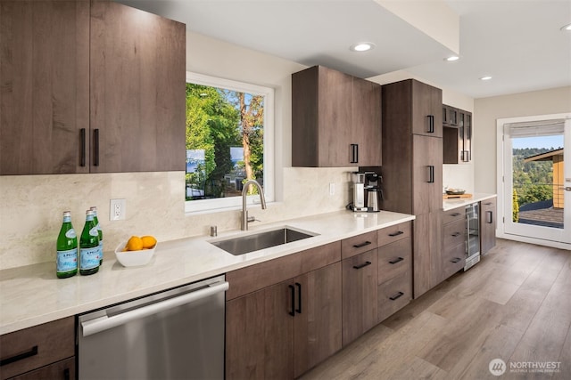 kitchen with beverage cooler, a sink, a healthy amount of sunlight, and stainless steel dishwasher