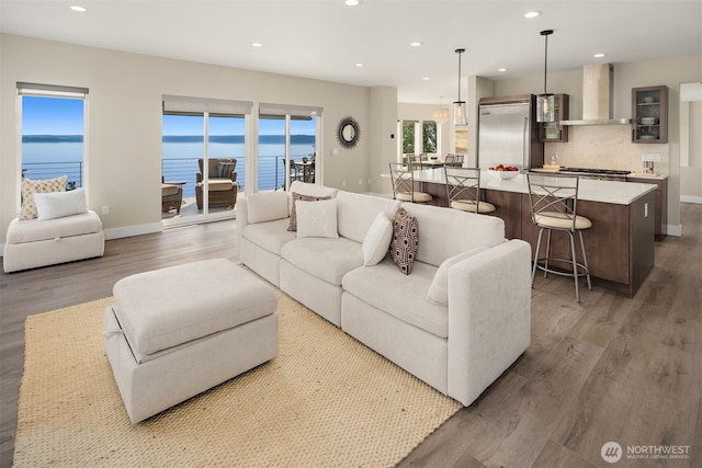 living room featuring recessed lighting, baseboards, and wood finished floors