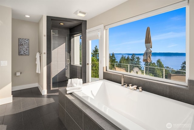 bathroom featuring a shower stall, baseboards, tiled tub, recessed lighting, and tile patterned floors