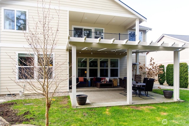 rear view of house featuring a balcony, a lawn, and a patio area