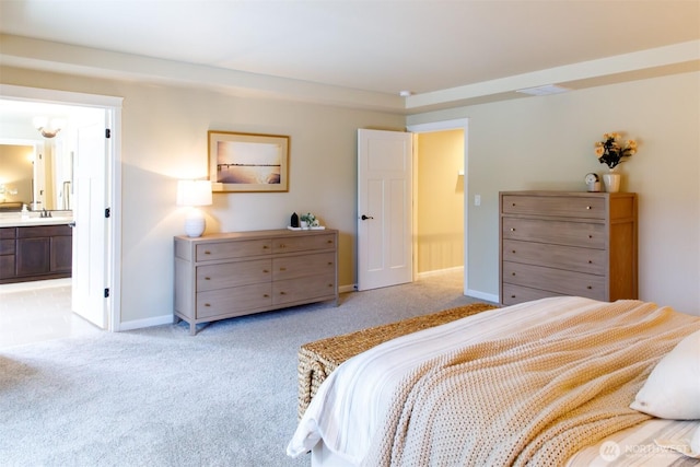 bedroom featuring visible vents, a sink, connected bathroom, baseboards, and light colored carpet