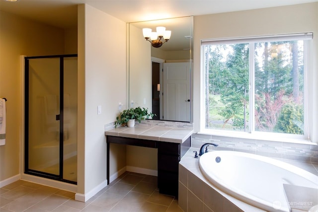 bathroom featuring a bath, a chandelier, a shower stall, and tile patterned floors