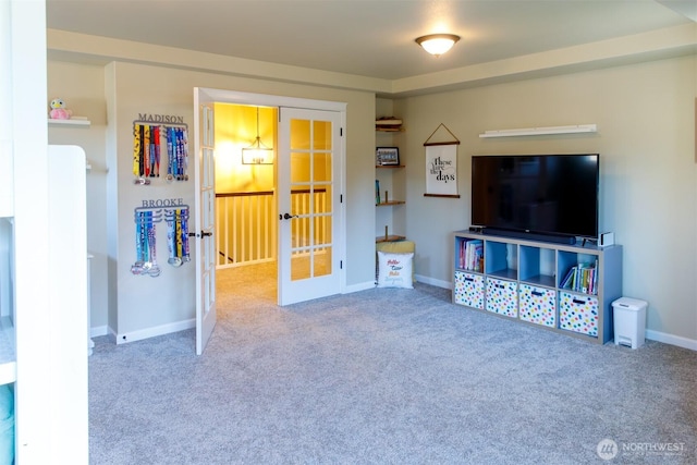 living area featuring french doors, carpet floors, and baseboards