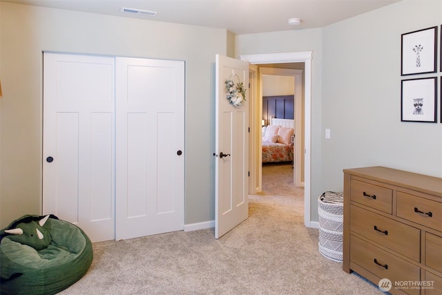 bedroom featuring baseboards, visible vents, a closet, and light carpet