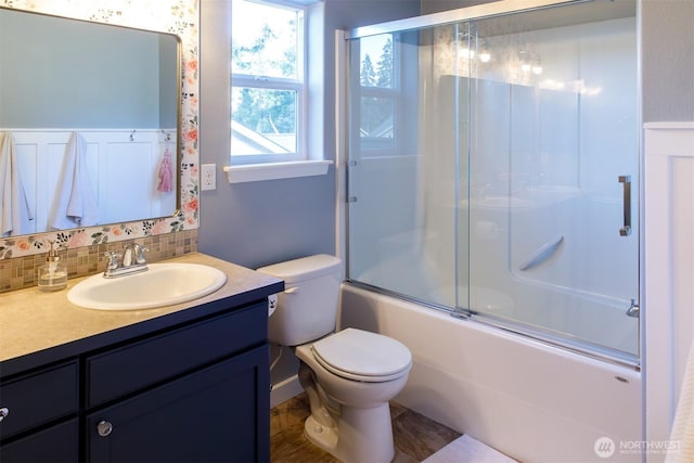 full bathroom with decorative backsplash, combined bath / shower with glass door, toilet, and vanity