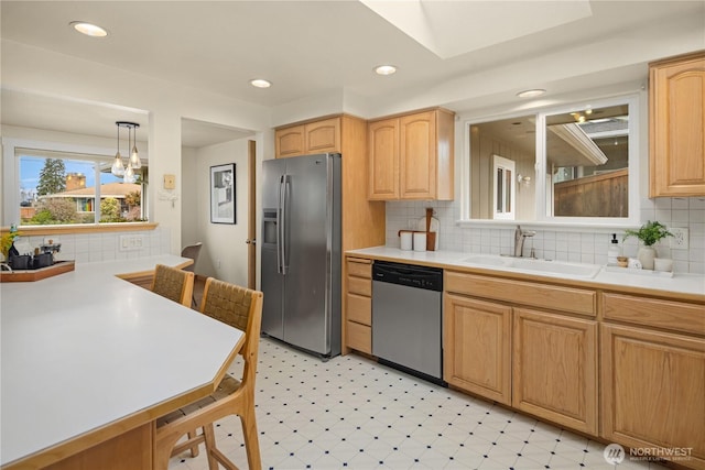 kitchen with light floors, recessed lighting, a sink, light countertops, and appliances with stainless steel finishes