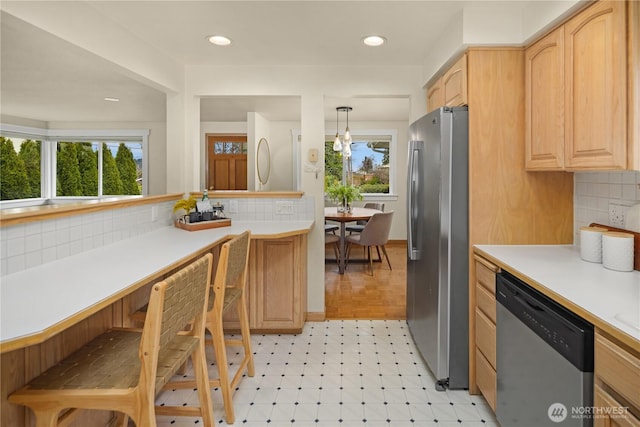 kitchen featuring stainless steel appliances, light floors, light brown cabinets, and light countertops