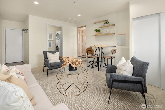 living room featuring light carpet, recessed lighting, and stacked washer and clothes dryer