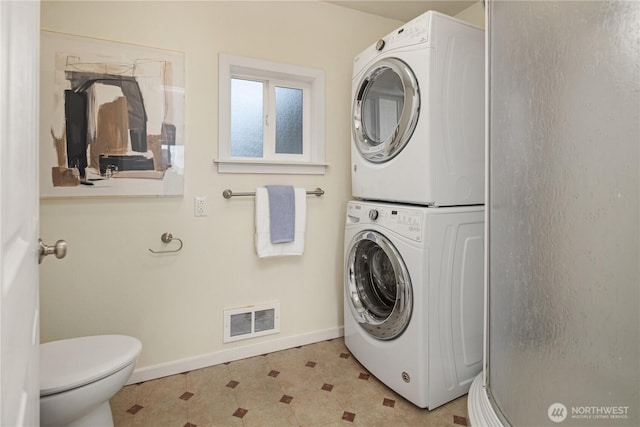 washroom featuring visible vents, baseboards, light floors, laundry area, and stacked washer and clothes dryer