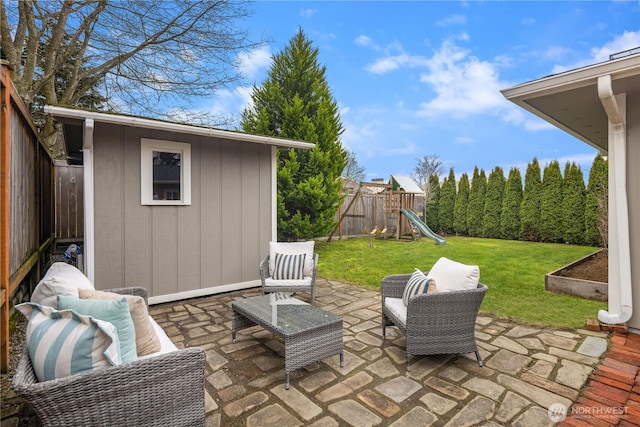 view of patio featuring an outdoor structure, a playground, a storage unit, and a fenced backyard