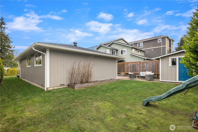 rear view of house featuring a yard, an outdoor living space, an outdoor structure, and fence