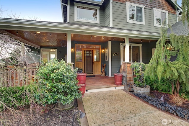 view of exterior entry featuring covered porch