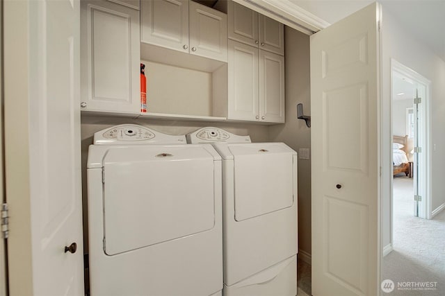 laundry room with cabinet space, baseboards, carpet floors, and washing machine and clothes dryer