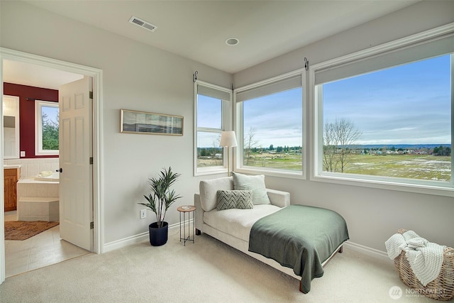 carpeted bedroom featuring visible vents, baseboards, and connected bathroom