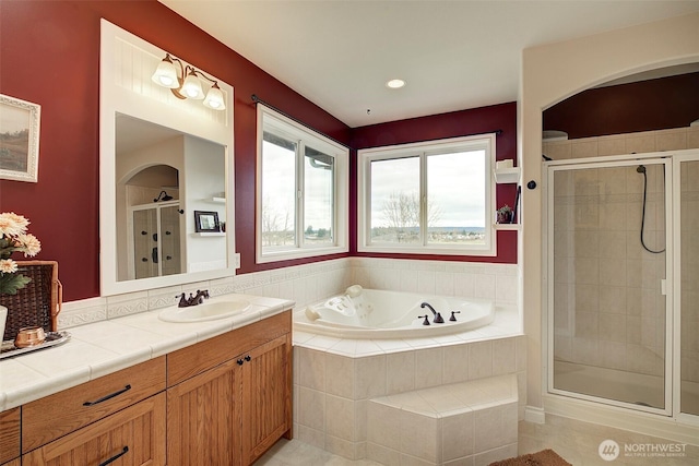 bathroom with vanity, a bath, and a stall shower