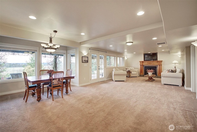 dining room with light colored carpet, french doors, a fireplace, and baseboards