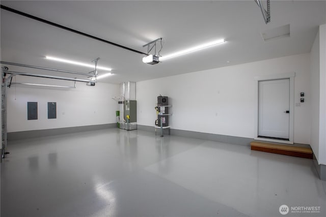 garage featuring electric panel, baseboards, and a garage door opener